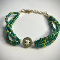 Green 8/0 seed bead triple strand bracelet with center focal piece and pearlescent accent beads